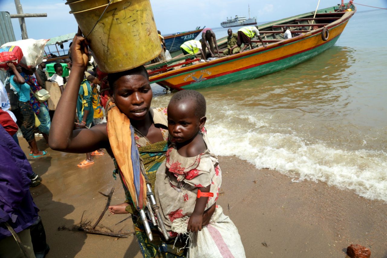 A mother carries her child ashore in Kigoma.