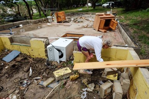 Janie Bell helps her neighbors in Wimberley search for possessions after their vacation home was destroyed in a flash flood on May 25.