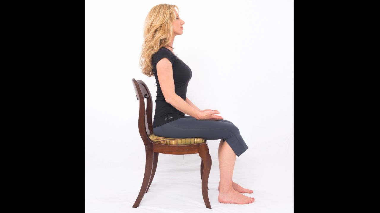 Sit comfortably with both feet on the floor. Establish good posture by exhaling as you drop your ribcage down in front and your shoulder blades down in back. Rest your hands on the tops of your legs with your palms up. Close your eyes. Relax your jaw, resting your lips in a slight smile. Take conscious control of your breathing, emphasizing your first few exhales, like sighs of relief. Tune out distractions, focusing all of your attention on expanding your lower ribs on inhalation and contracting them on exhalation. Try breathing long and deep at the following pace: 5-count inhale, 7-count exhale. Once you've established a comfortable breathing rhythm, count your breaths backwards from ten to one. Open your eyes and notice your profound change in perspective.  