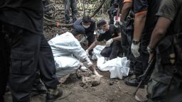 A Royal Malaysian Police forensic team handles exhumed human remains in a jungle at Bukit Wang Burma in the Malaysian northern state of Perlis, which borders Thailand, on May 26, 2015. Malaysian police May 26 began the grisly job of exhuming dozens of graves found in a series of remote human-trafficking camps along the Thai border in the latest grim turn in the region's migrant crisis. Police said May 25 they had found 139 grave sites and 28 abandoned detention camps used by people-smugglers and capable of housing hundreds, laying bare the grim extent of the region's migrant crisis. AFP PHOTO / MOHD RASFANMOHD RASFAN/AFP/Getty Images