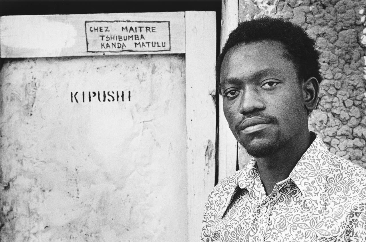 Painter Tshibumba Kanda Matulu posing in front of his home/studio. 