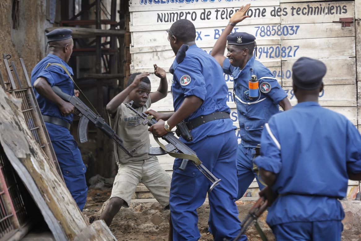A young Burundian boy tries to cover himself as police officers beat him at an anti-government demonstration in Bujumbura on Tuesday, May 26.
