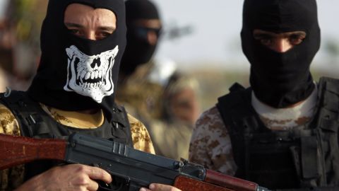 Iraqi Sunni men presented as former jihadists fighting alongside ISIS who defected to join Iraq government forces take position in Amriyat al-Falluja, in Iraq's Anbar province, on May 26, 2015.