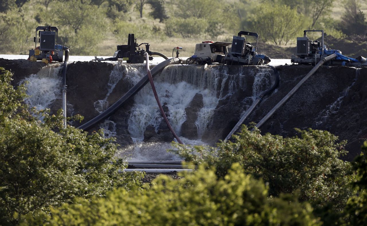 Workers in Midlothian, Texas, try to relieve pressure from the dam at Padera Lake on May 27.