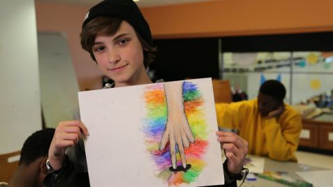 A student shows off his artwork created at one of the free ProjectArt classes in New York City.