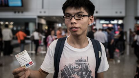 Joshua Wong shows his boarding pass as he talks to the media at the international airport in Hong Kong on May 26. 