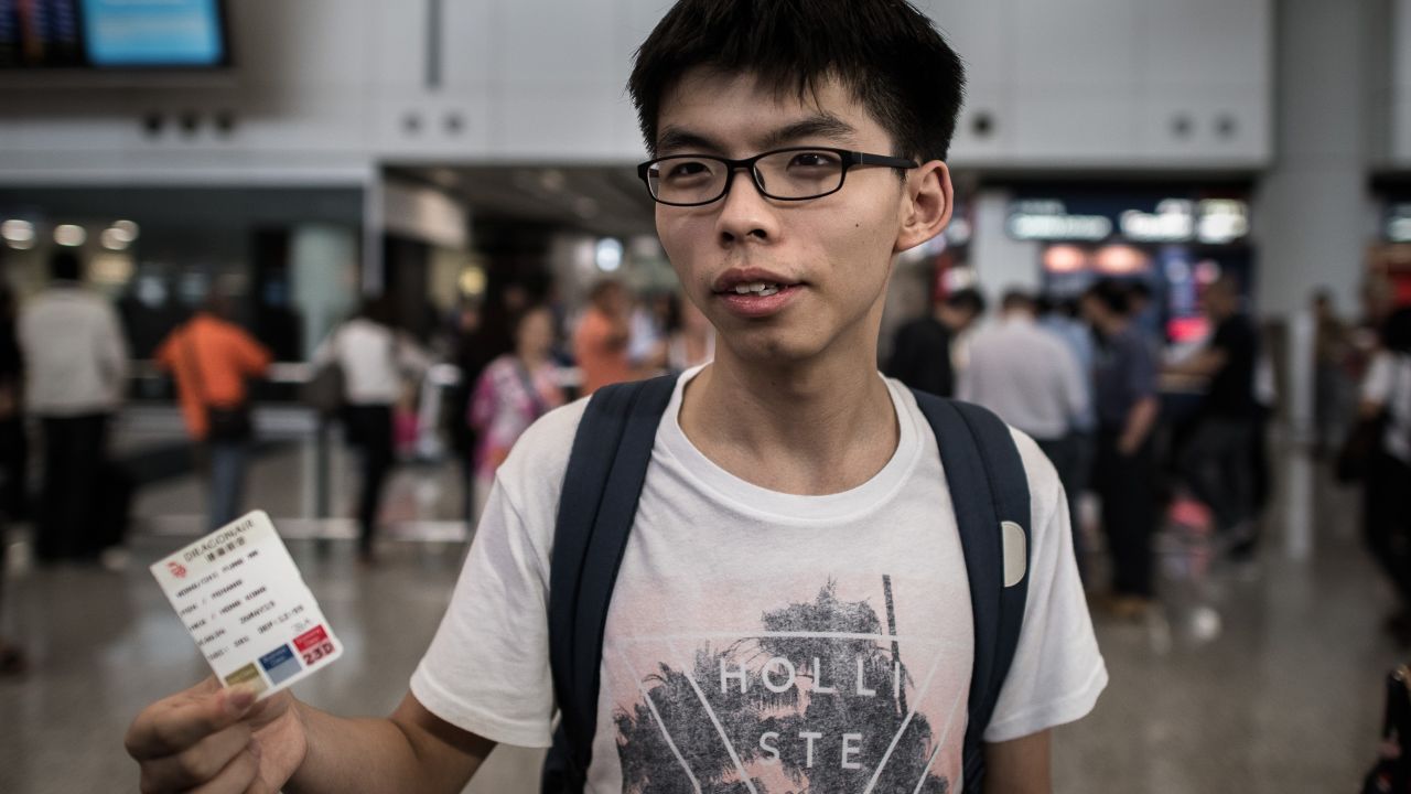 Joshua Wong shows his boarding pass as he talks to the media at the international airport in Hong Kong on May 26.
