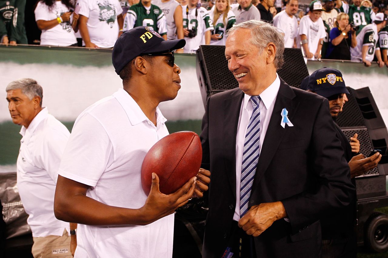 in this photo, Pataki talks with rapper Jay-Z on the sideline as the New York Jets play against the Dallas Cowboys during their NFL Season Opening Game at MetLife Stadium on September 11, 2011 in East Rutherford, New Jersey.