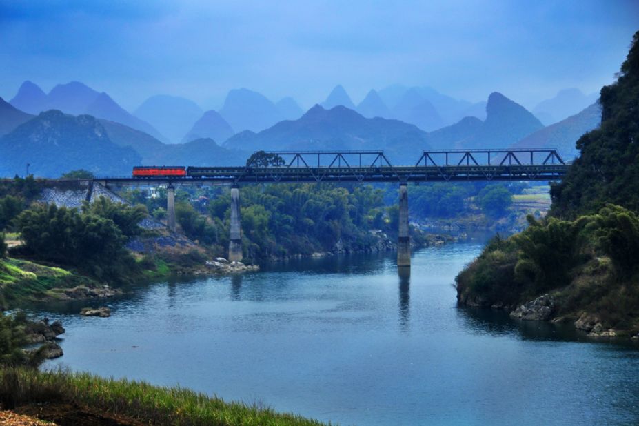 "The Longjiang Bridge is a steel-truss bridge spanning the beautiful Longjiang River," says Beijing-based train photographer Wang Wei. "Here you can see obvious karst topography. To take this photo, I climbed on a hillside with many plants with thorns and fell into a two-meter-deep hole. I was OK, just scared afterward -- what if it was a much deeper hole?"  