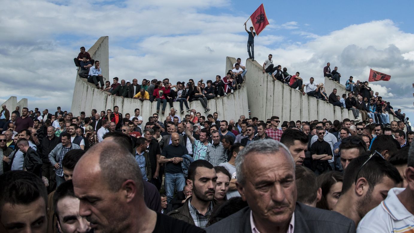 People in Kosovo's capital of Pristina attend a burial ceremony Tuesday, May 26, for eight ethnic Albanians who were killed during fighting with police earlier this month in Kumanovo, Macedonia. Police officers were also killed in the clashes.