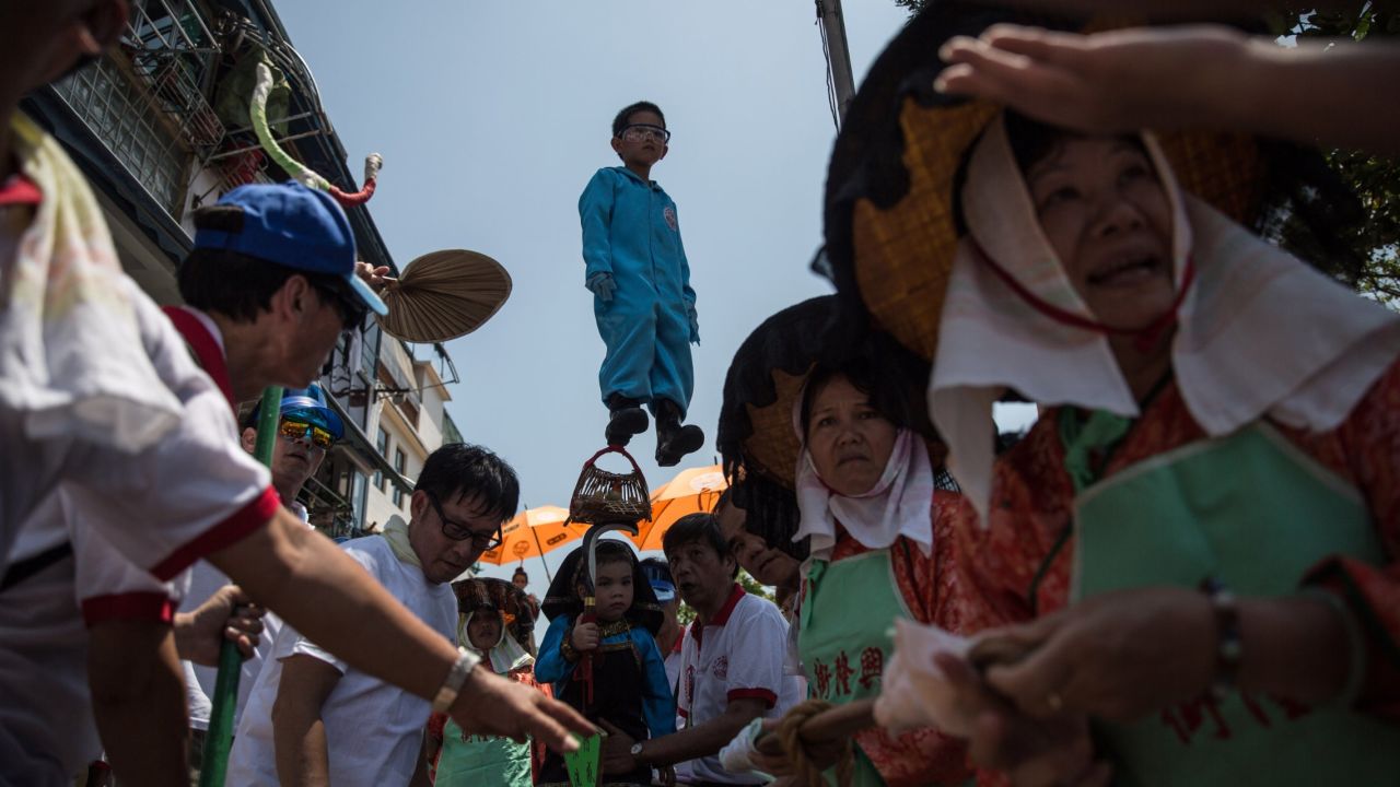 A young boy dressed as a deity is paraded on a float during the Bun Festival in Hong Kong on Monday, May 25. The Bun Festival is held every year to placate the hungry ghosts of old pirates. 