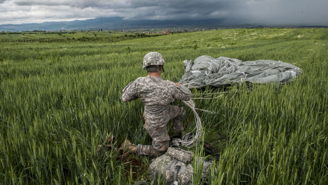 A U.S. paratrooper packs his parachute during a drill in Kosovo on Wednesday, May 27.
