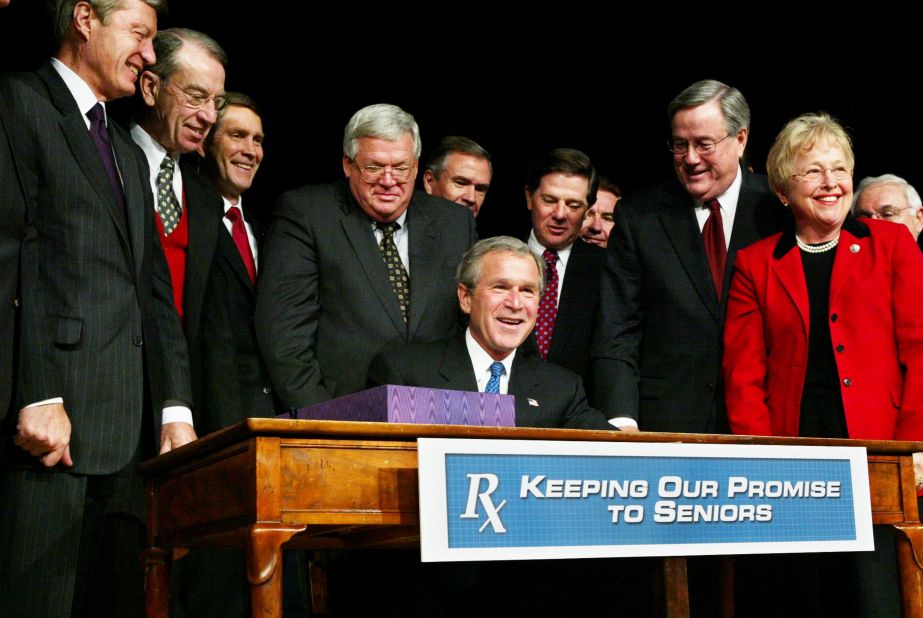 Hastert stands behind President George W. Bush as he signs Medicare legislation in December 2003. Hastert fought hard for the bill in the House, leading to a three-hour vote on November 22, 2003. 