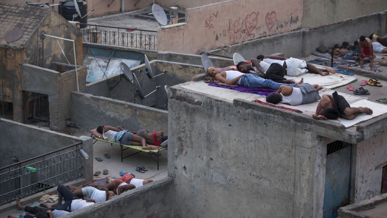 People sleep on roofs in New Delhi on May 29, to escape the heat trapped in their concrete homes on. A blistering heat wave has killed more than 1,300 people in the country.