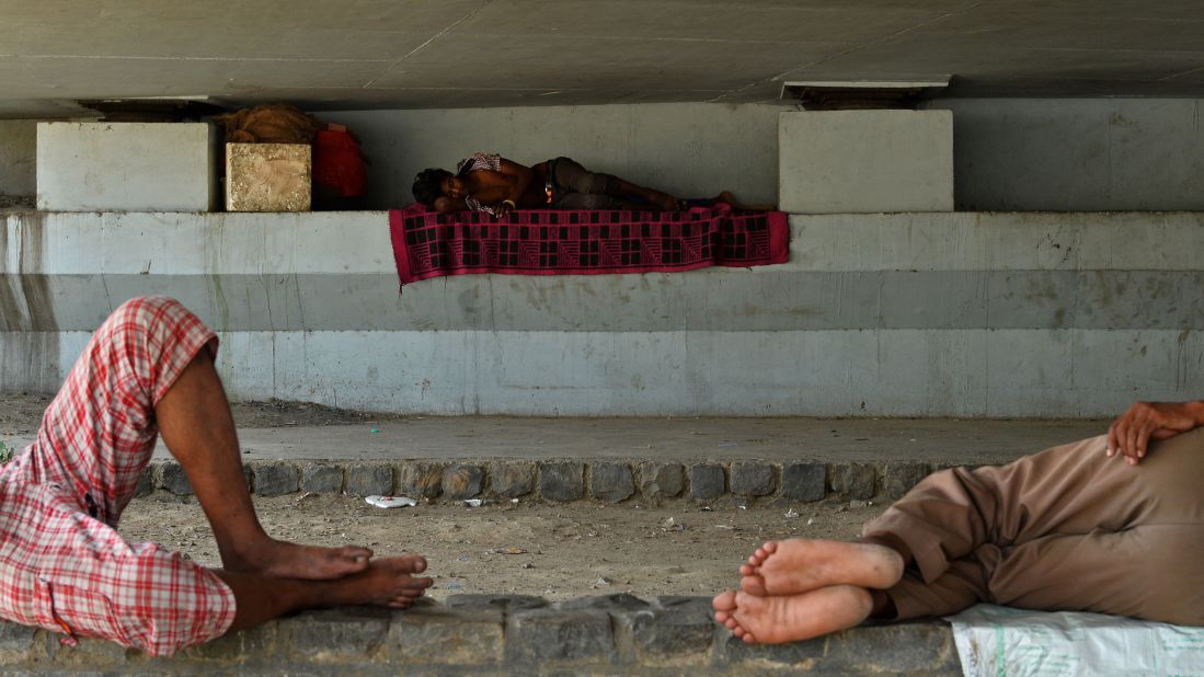 Men sleep in the shade under a bridge in New Delhi on May 27.