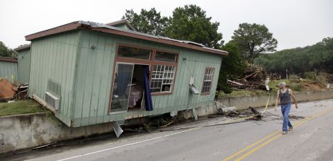 On Tuesday, May 26, a Wimberley man walks past a cabin that was torn from its foundation days earlier.