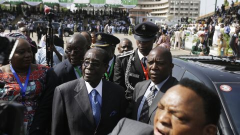 Zimbabwean President Robert Mugabe, in the blue tie, arrives for the inauguration.