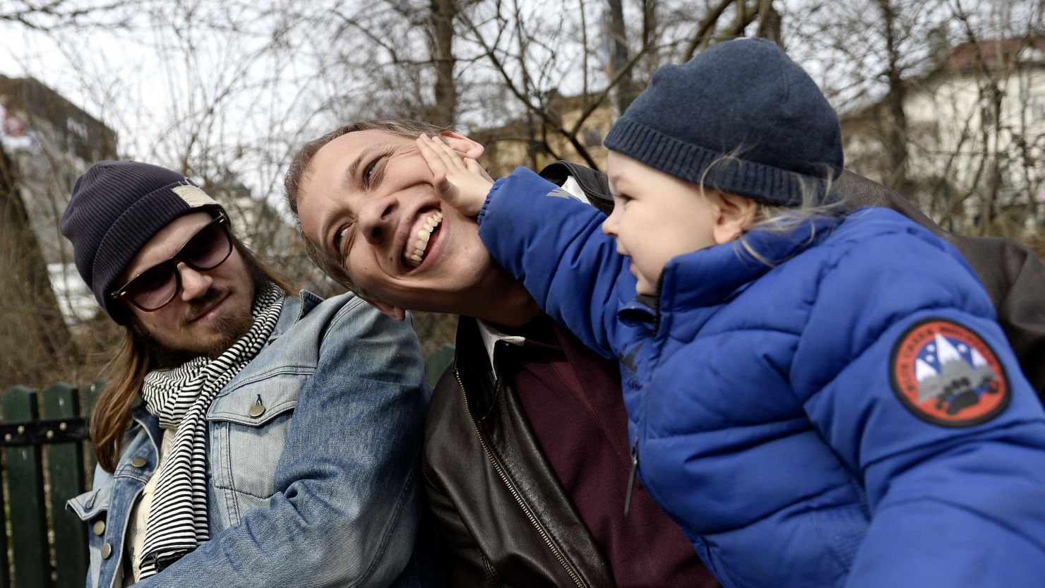 Anders Veide looks on as his friend Set Moklint plays with his son Wilhelm during a paternity leave outing at a park in Stockholm on April 24, 2013.