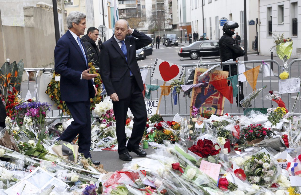 Kerry walks with French Foreign Minister Laurent Fabius in Paris on January 16 through a memorial to the victims killed in the attack on the satirical newspaper Charlie Hebdo.