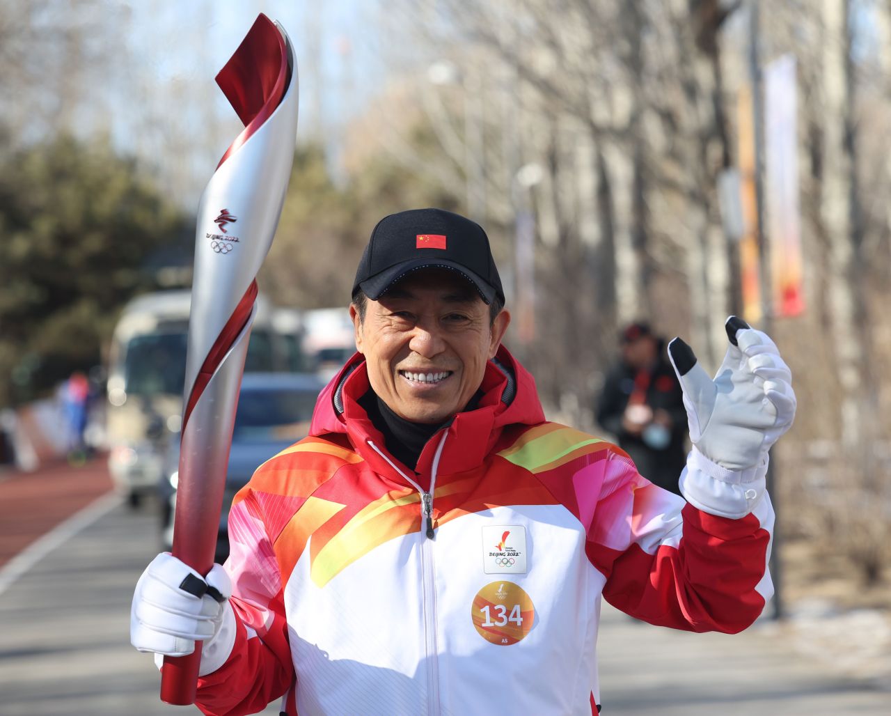 Zhang Yimou runs with the torch during the 2022 Olympic Torch Relay at the Olympic Forest Park in Beijing, on Feb. 2.