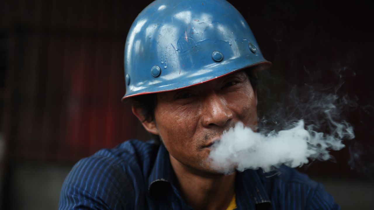 This photo taken on May 28, 2015 shows a worker smoking during a break at a demolition site in Beijing.