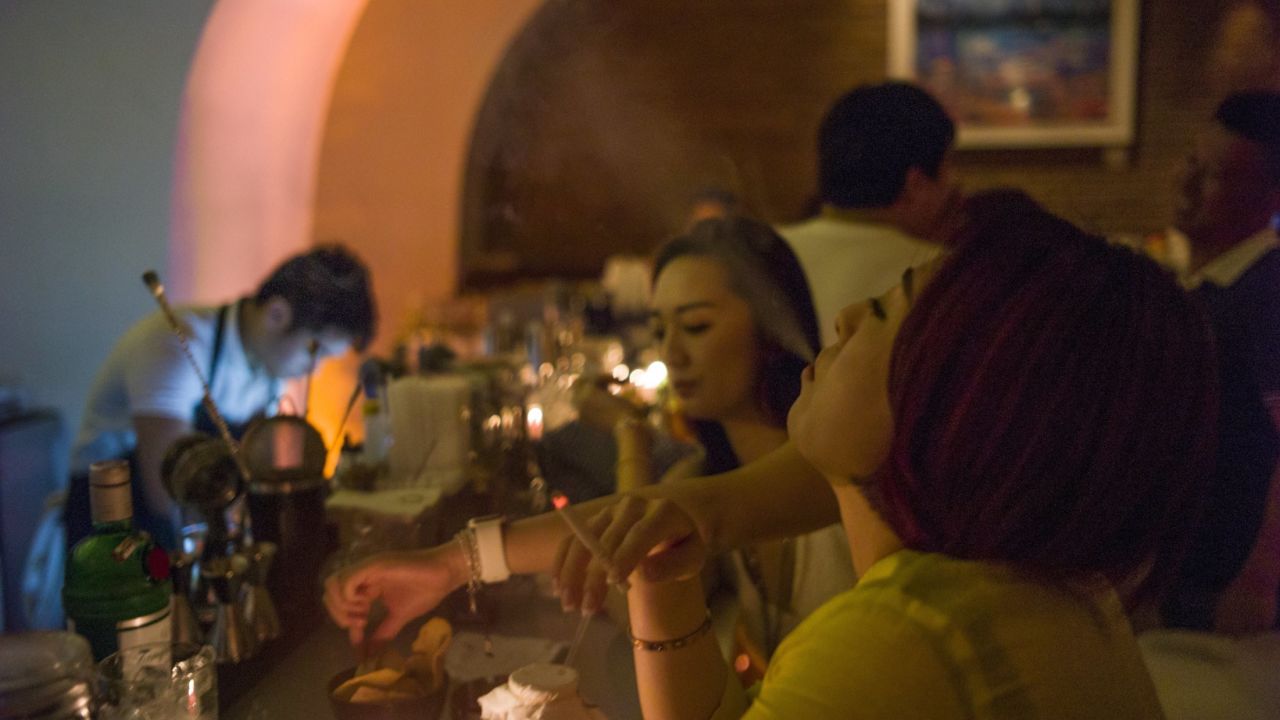 People smoke cigarettes in a bar on May 27, 2015 in Beijing.