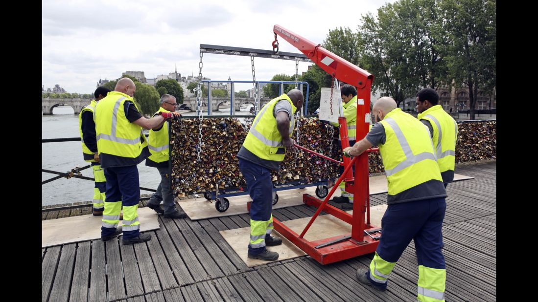 Paris city employees remove a railing loaded with locks on the Pont des Arts bridge on Monday, June 1. For years, couples have put locks on the bridge to symbolize their affection -- a tradition often followed by throwing the key into the Seine River below. But the city is now removing the padlocks because sections of the bridge's fencing started crumbling under the locks' weight.