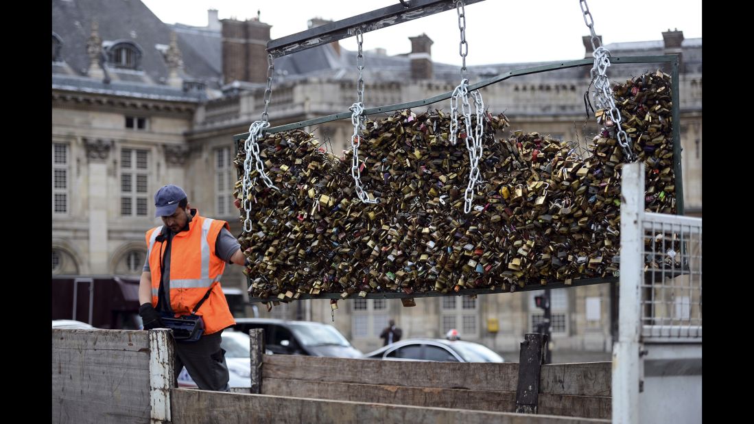 A man works to remove locks attached to the bridge on June 1.