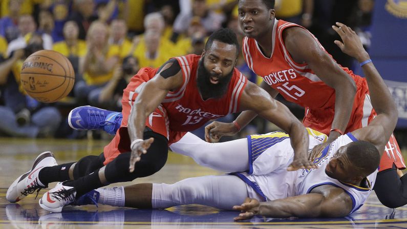 Houston's James Harden, left, reaches for a loose ball over Golden State's Festus Ezeli on Wednesday, May 27. Golden State won the game 104-90, clinching a spot in the NBA Finals.