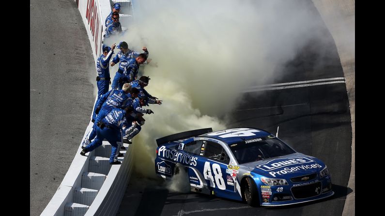 NASCAR driver Jimmie Johnson is cheered by his team while he celebrates his Sprint Cup victory in Dover, Delaware, on Sunday, May 31. It was his fourth win of the season.
