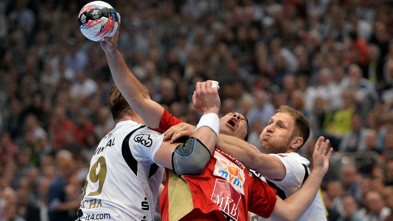 Veszprem handball player Jose Maria Rodriguez Vaquero is tackled by Kiel players on Saturday, May 30, during the semifinals of the Champions League in Cologne, Germany.