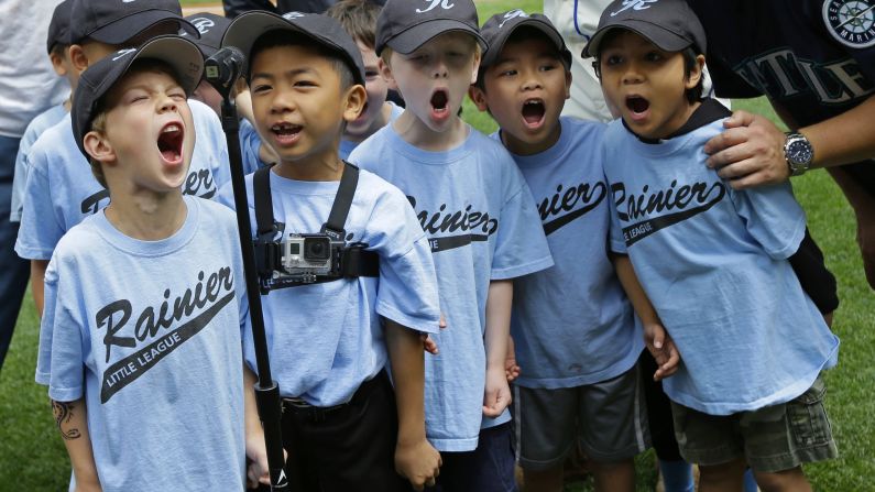 Players from the Blue Rockets, a Little League team from Rainier, Washington, yell "Play ball!" before the start of a Major League Baseball game in Seattle on Sunday, May 31.