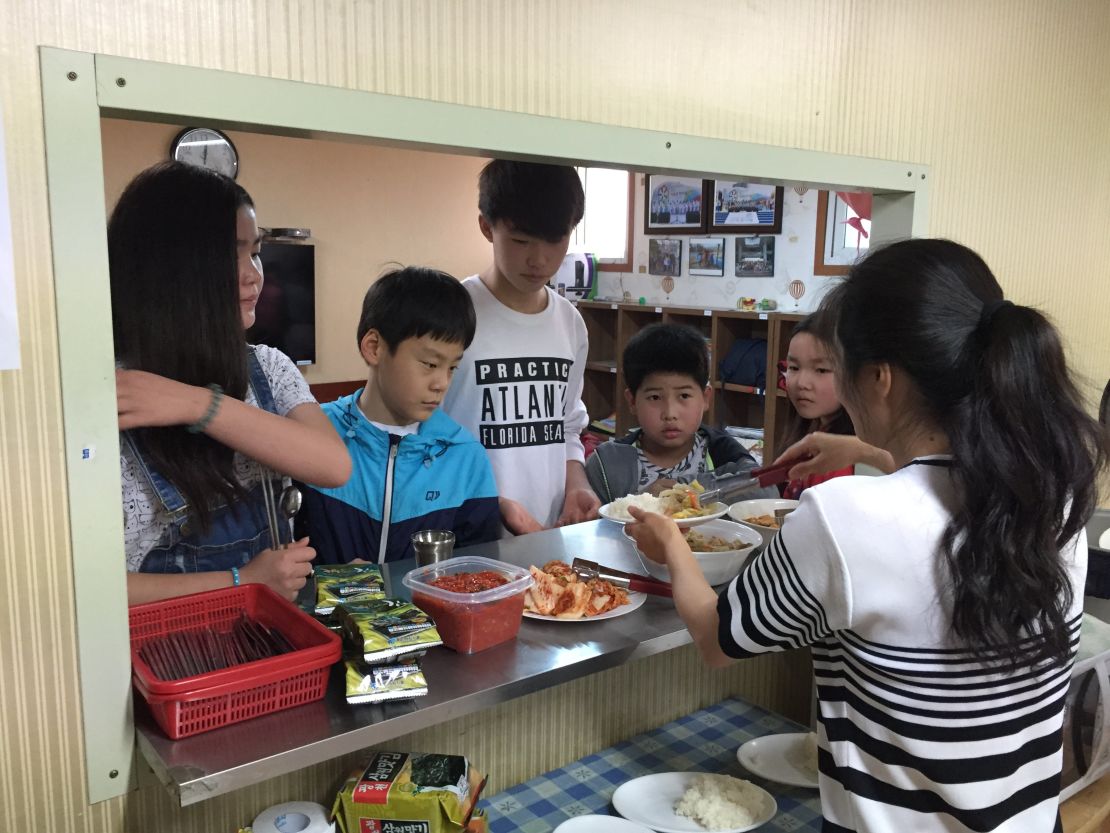 Children queue for lunch at the Kumgang school in Seoul.