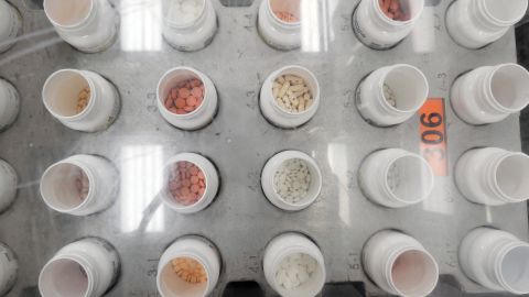 Bottles of prescription pills go through an automated packaging machine at a pharmacy plant in New Jersey.   