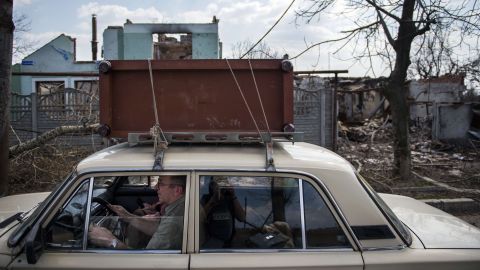 Residents flee with salvaged belongings during renewed fighting in the Jabunki neighborhood near the airport in Donetsk on Monday, April 13.