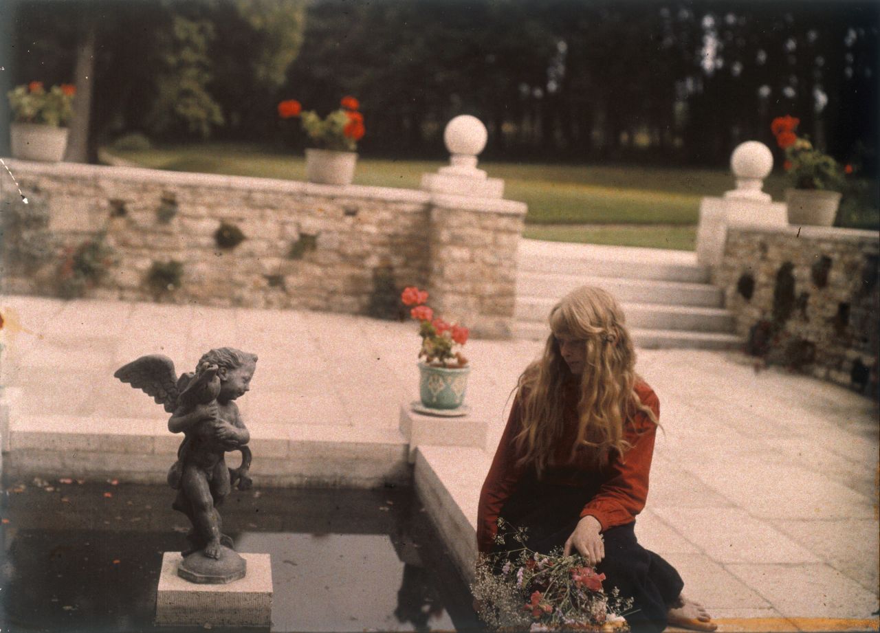 Seemingly unaware of the camera in almost every shot, the young girl is captured here while gazing into an ornamental pond.<br />The location for this photograph is not known, but it may possibly have been taken at the gardens of Rempstone Hall, near Corfe Castle, in Dorset.