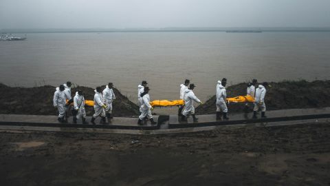 Rescue personnel carry the bodies of victims away from the banks of the Yangtze River in Jianli County, China, on Wednesday, June 3.