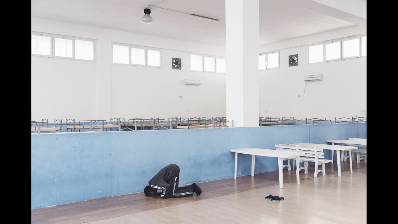 Amdi prays in a nearly empty room.