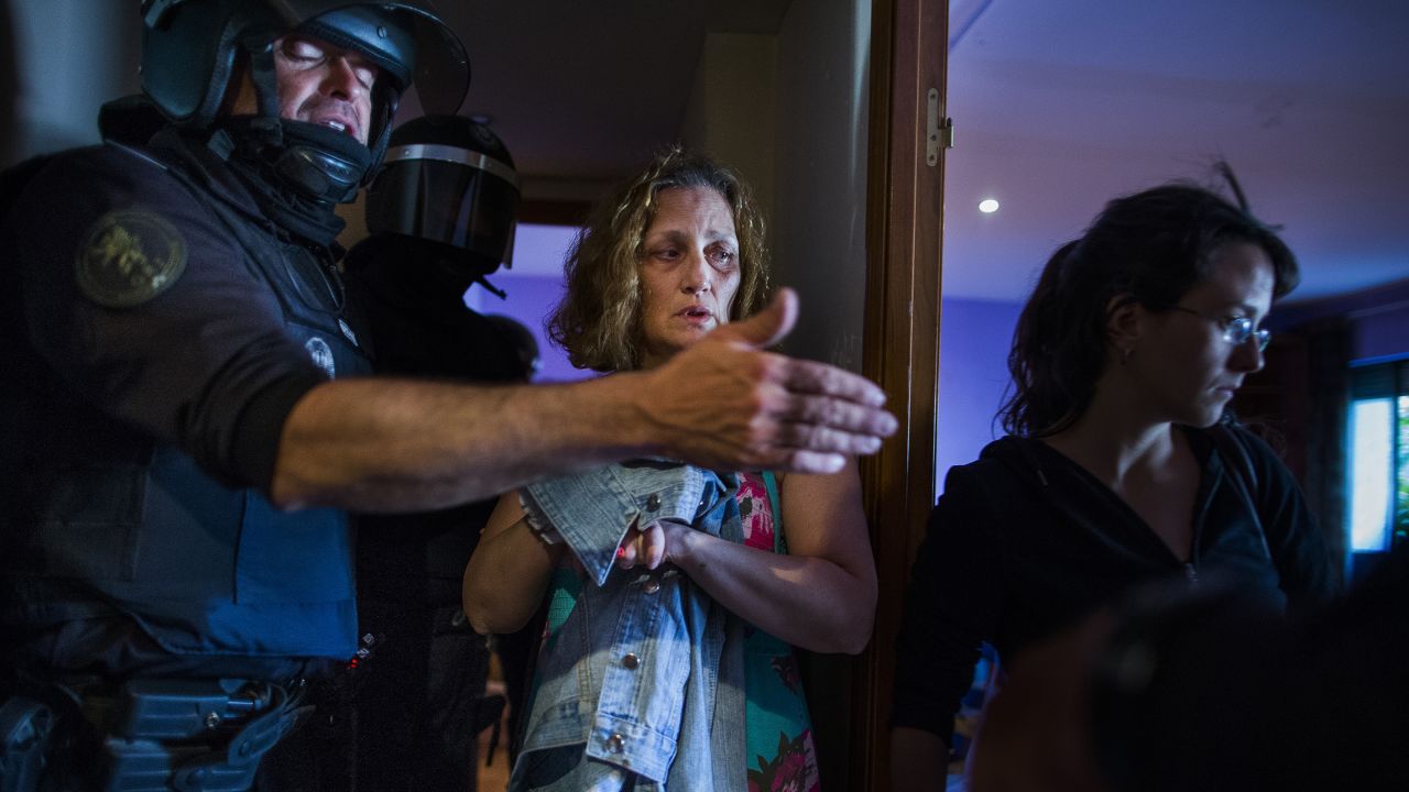 Police enter the Madrid apartment of Carmen Rives, center, to evict her on Tuesday, June 2. The eviction was carried out by dozens of police officers who also arrested at least 12 anti-eviction activists. Evictions in Spain have soared since the country's economic crisis began in 2008, and protesters regularly try to prevent them.