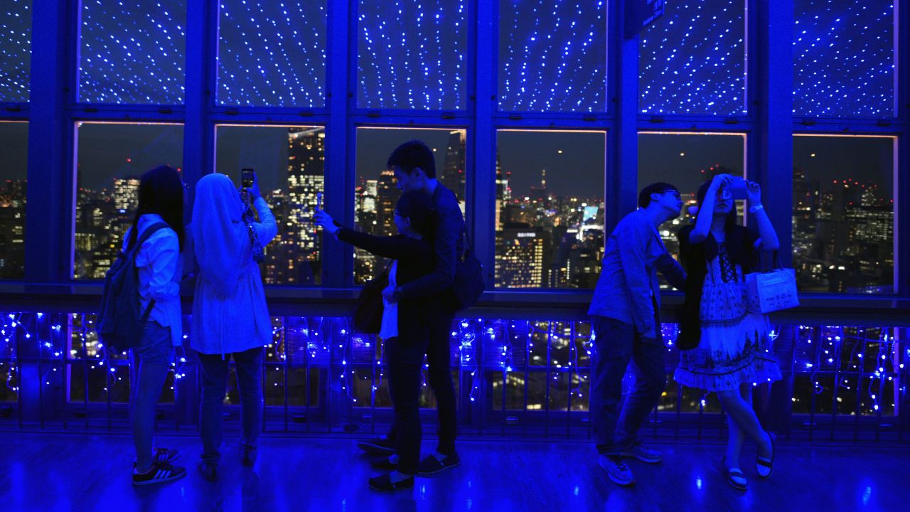 Visitors of Tokyo Tower take photographs under LED lights representing the Milky Way on Monday, June 1.