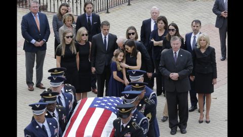 Natalie Biden, center, is comforted by her grandfather and her mother as they follow the honor guard carrying the casket. 