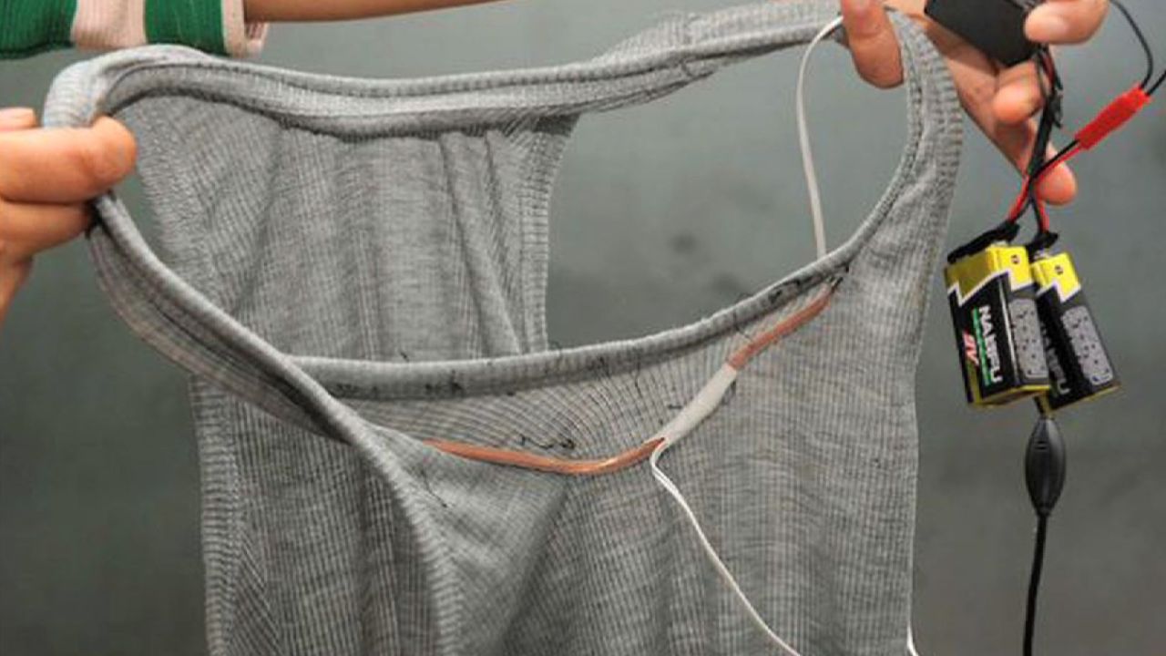 A wire runs along a T-shirt, presumably to a listening device worn by the student.