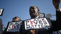 Men holding signs reading 'Black Lives Matter' march in the 30th annual Kingdom Day Parade in honor of Dr. Martin Luther King Jr., January 19, 2015 in Los Angeles, California. 2015 is the 50th anniversary of the historic 1965 Selma to Montgomery Alabama freedom marches which played a pivotal role in the civil rights struggle for racial equality in the U.S. AFP PHOTO / ROBYN BECK 