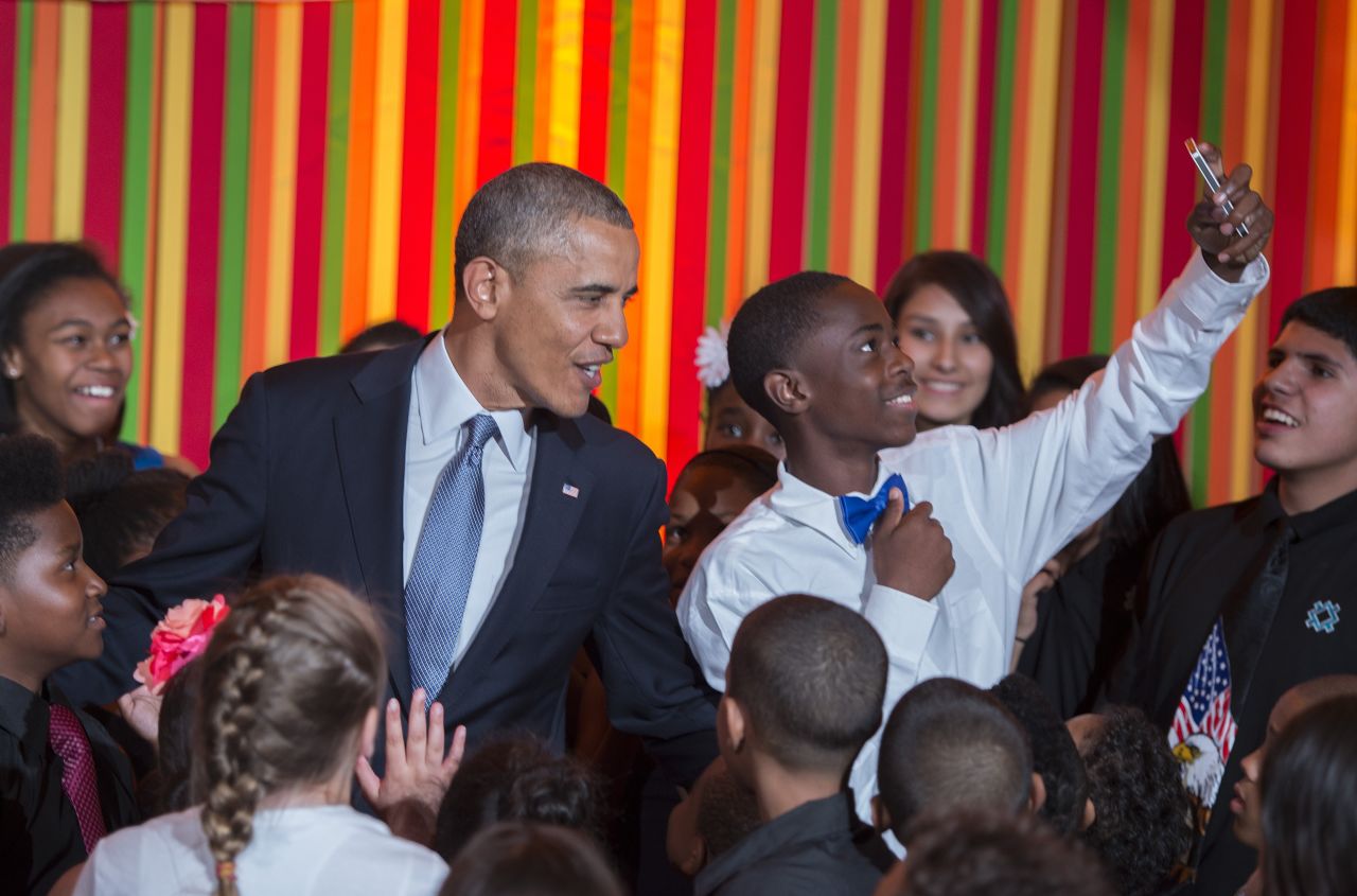 A student takes a selfie as Obama makes a surprise visit to the White House Talent Show in May 2014.