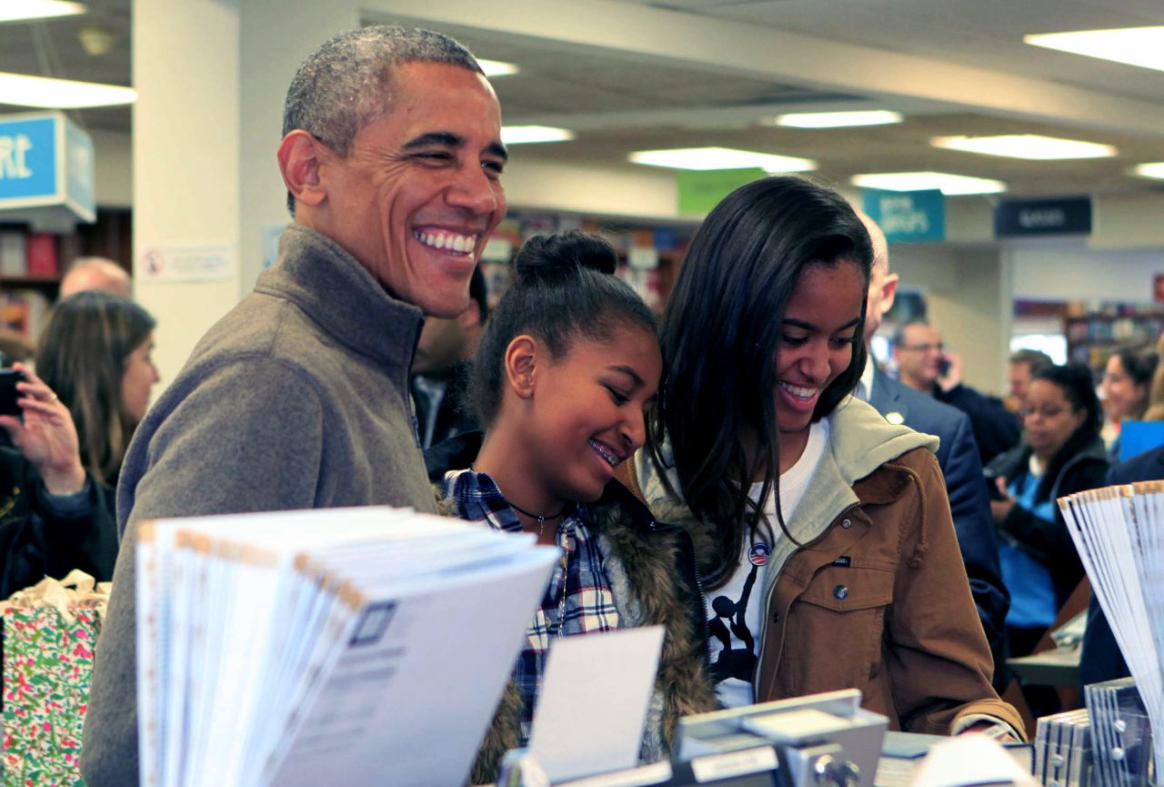 Obama buys books with his own kids, Sasha, center, and Malia, at Politics and Prose bookstore in Washington in November.
