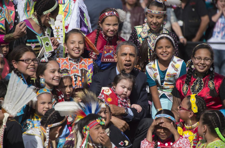 Obama holds a child as he poses with Native American performers during the Cannon Ball Flag Day Celebration in Cannon Ball, North Dakota, in June 2014.