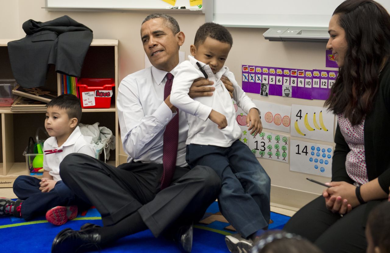 Obama puts student Marcus Wesby in his lap as he sits with children during a tour of a pre-K classroom at Powell Elementary School in Washington in March 2014.