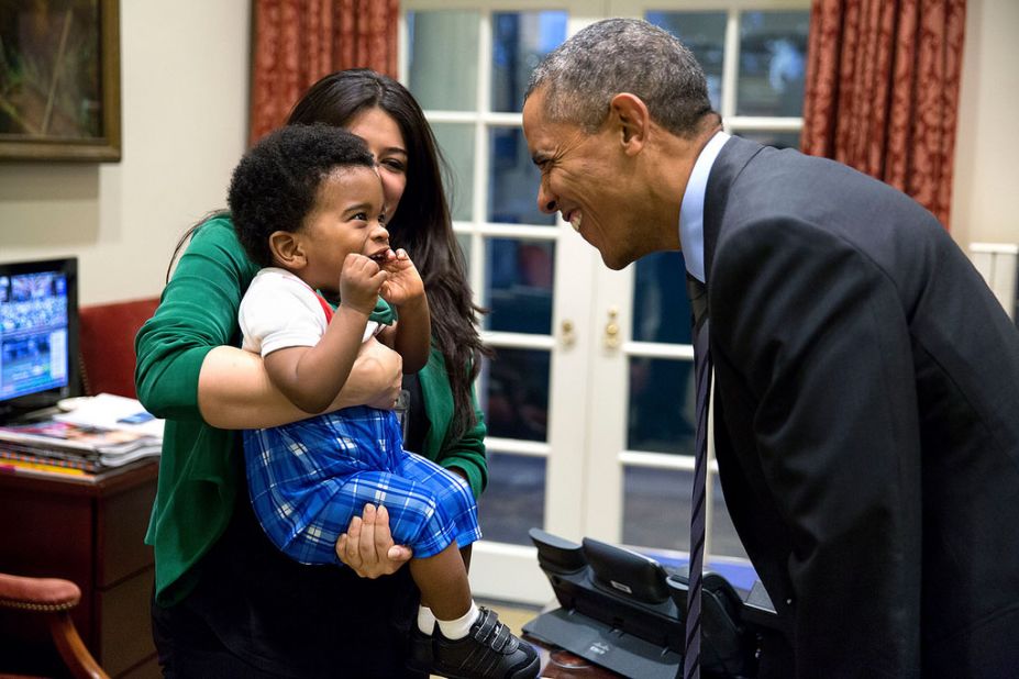 Obama greets a little boy held by Ferial Govashiri, personal aide to the president, in October. 
