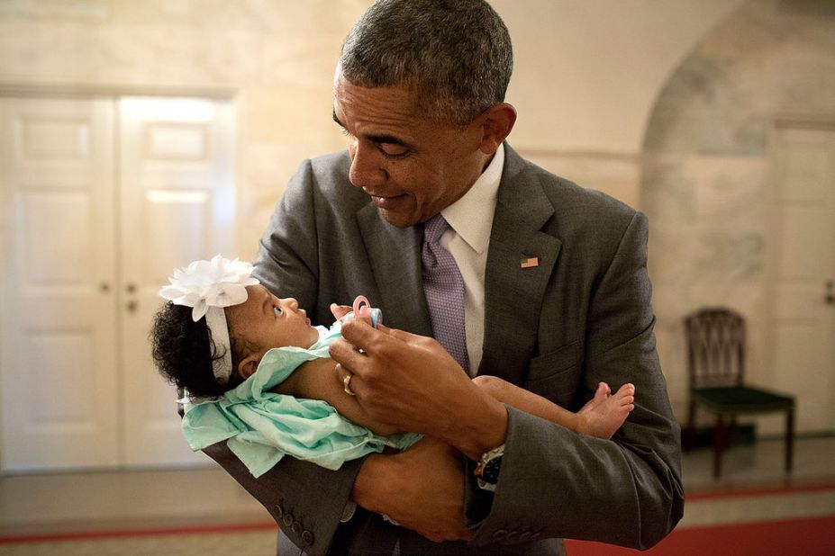 Obama holds the daughter of former staff members Darienne Page Rakestraw and London Rakestraw at the White House in July.