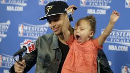 Golden State Warriors guard Stephen Curry is joined by his daughter Riley at a news conference after Game 5 of the NBA basketball Western Conference finals against the Houston Rockets in Oakland, Calif., Wednesday, May 27, 2015.